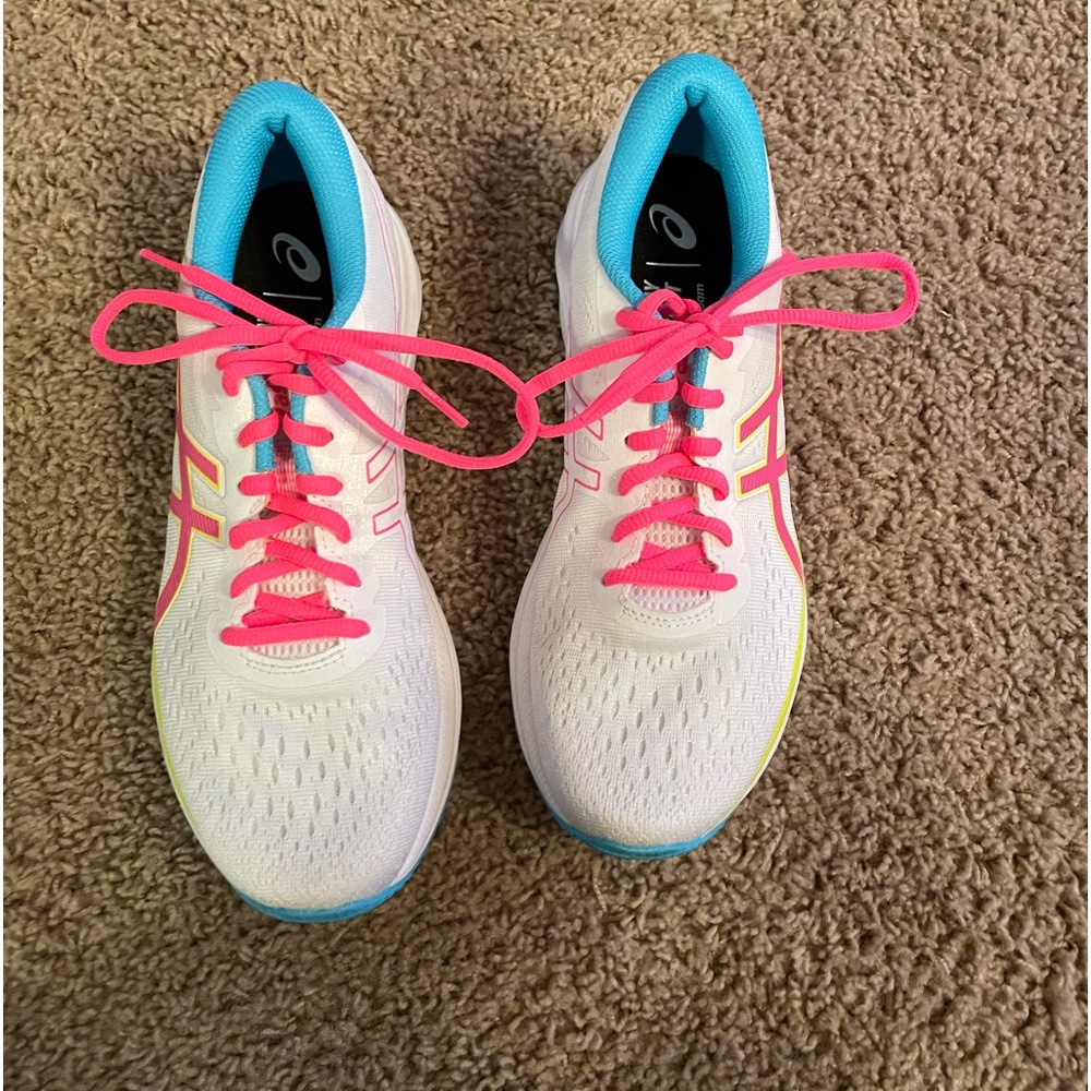 White with pink and blue accent colors. Only worn twice at an indoor gym.